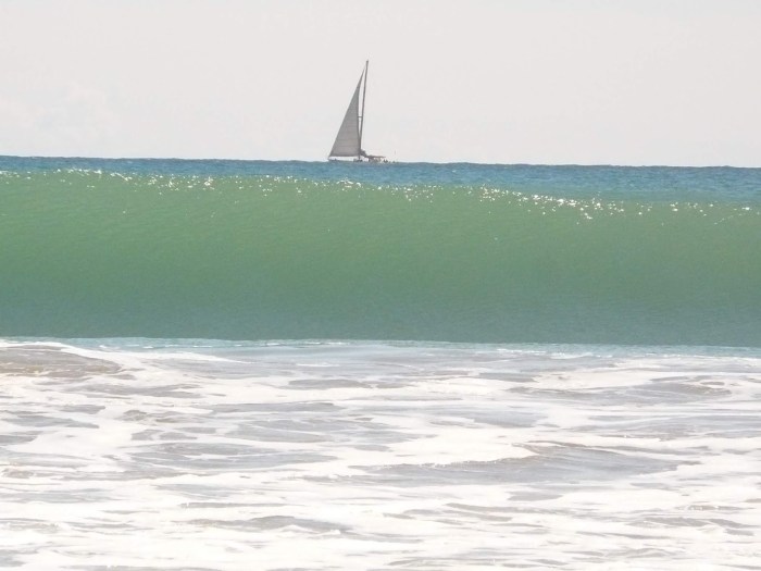Barco de vela y ola de mar