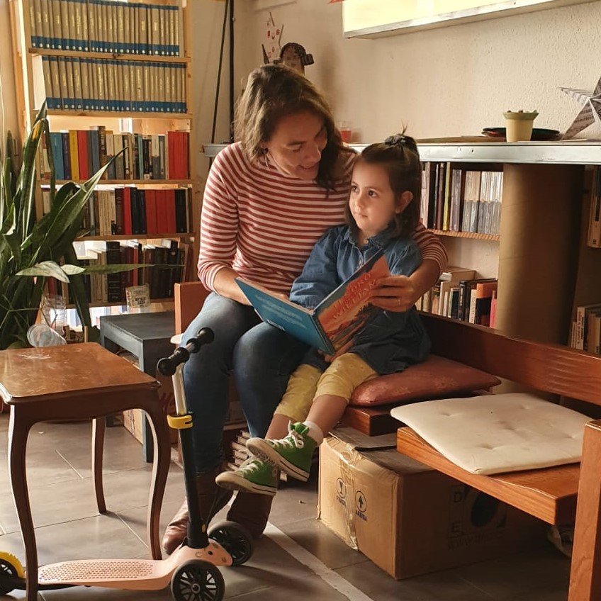 Tía y sobrina sentadas leyendo un libro